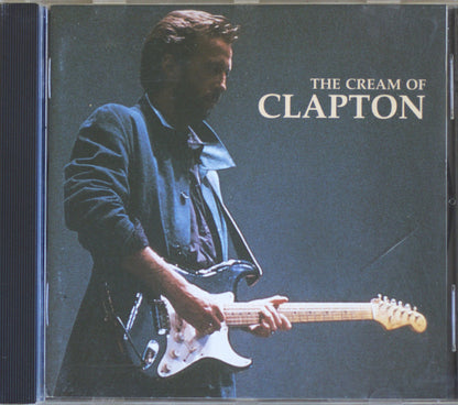CD cover for 'The Cream of Clapton' featuring a photo of Eric Clapton playing an electric guitar against a dark blue background, with the title in white text.