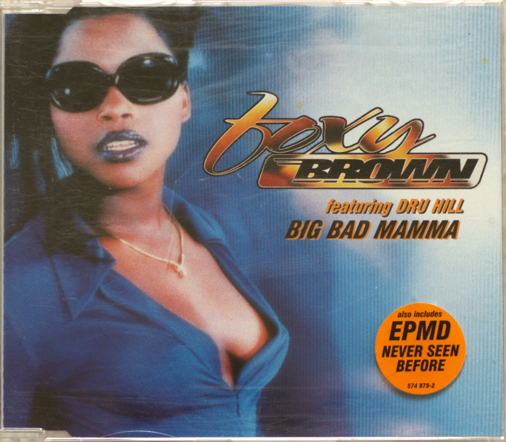 CD cover for Foxy Brown 'Big Bad Mama' featuring Dru Hill, with a portrait of a woman in sunglasses and a blue top against a blue gradient background. The title 'Big Bad Mama' is printed in large gold and black text, with an orange circular sticker reading 'EPMD Never Seen Before'.