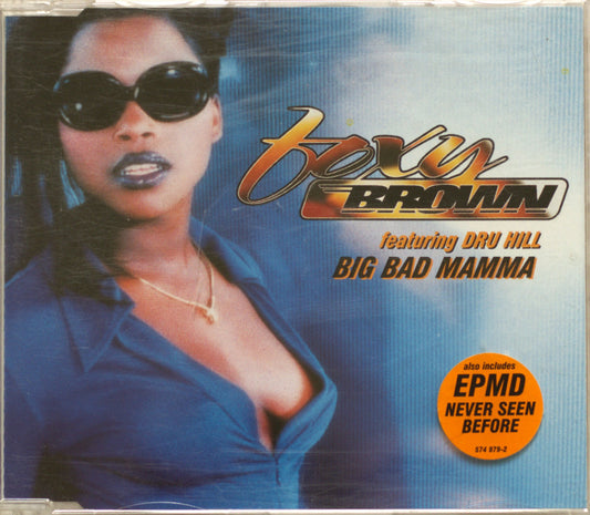 CD cover for Foxy Brown 'Big Bad Mama' featuring Dru Hill, with a portrait of a woman in sunglasses and a blue top against a blue gradient background. The title 'Big Bad Mama' is printed in large gold and black text, with an orange circular sticker reading 'EPMD Never Seen Before'.