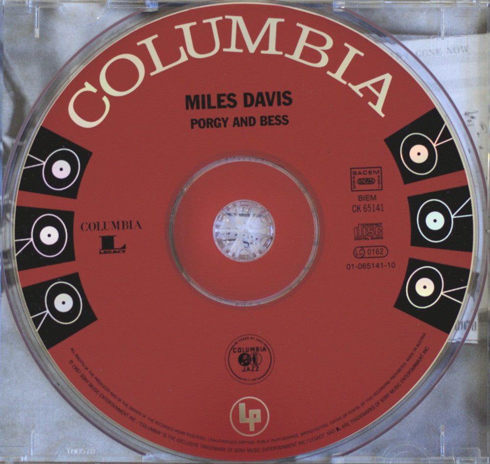A close-up of a Columbia Records CD for Miles Davis's album 'Porgy and Bess', showing the red center label with black and gold graphics inside a clear plastic jewel case.