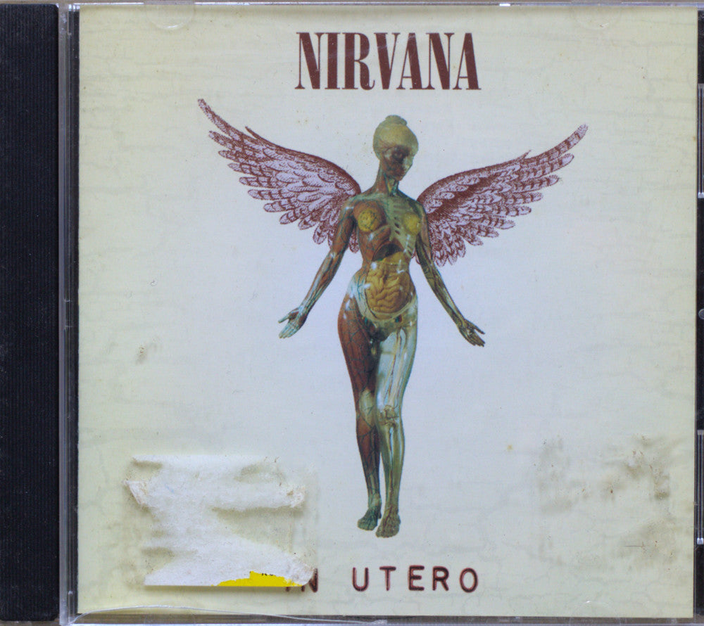 Nirvana - In Utero CD album cover, showing a winged anatomical female figure on a cream-colored cover with the band name at the top.