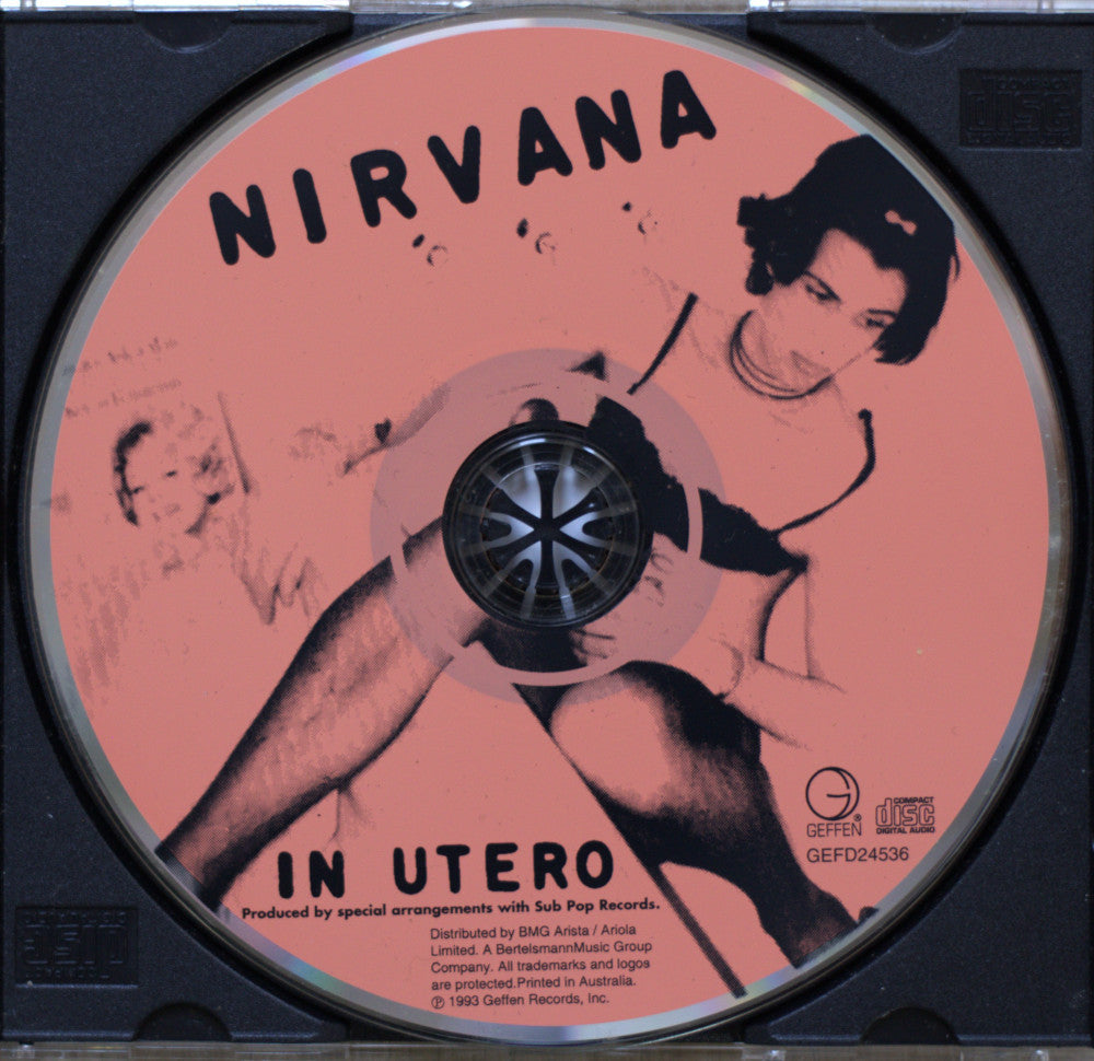Nirvana 'In Utero' CD cover inside a black jewel case, showing the pink-and-black printed disc artwork with the band name and album title.