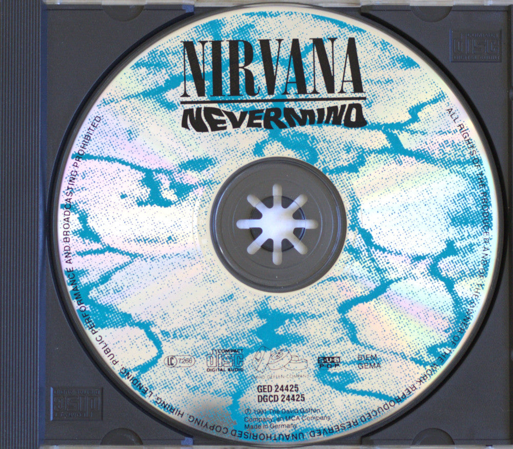 A Nirvana 'Nevermind' CD disc inside a black jewel case, showing the front cover artwork with blue and white marbled design and black text.
