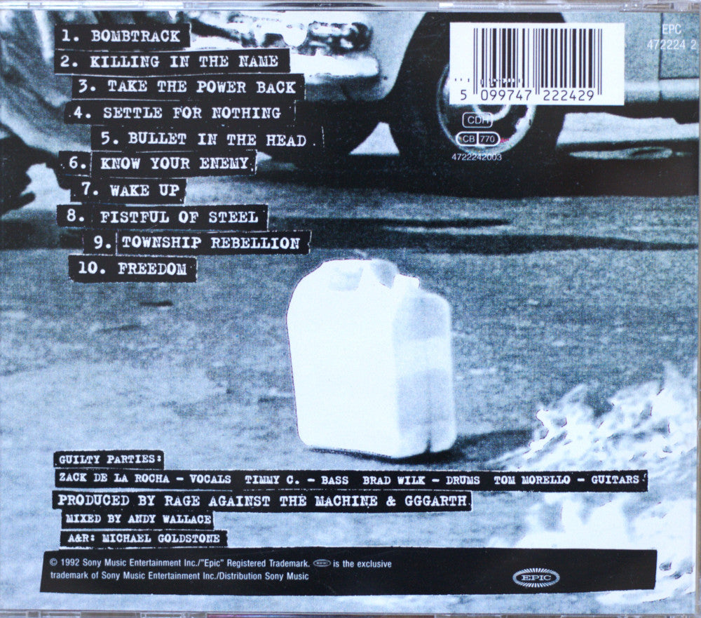The back cover of a music CD for Rage Against the Machine, featuring a black and white photograph of a milk jug on a street with a motorcycle in the background, complete with a tracklist and barcode.