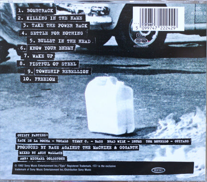 The back cover of a music CD for Rage Against the Machine, featuring a black and white photograph of a milk jug on a street with a motorcycle in the background, complete with a tracklist and barcode.