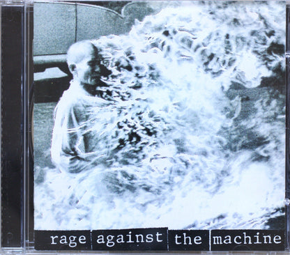 CD cover for the band 'Rage Against the Machine', featuring a grainy black-and-white photo of a person partially obscured by a chaotic, flame-like white overlay, with the band name printed in white text on a black bar at the bottom.