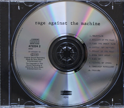 A CD disc from the album 'Rage Against the Machine' in a clear jewel case, showing the reflective silver disc with printed tracklist and center label.