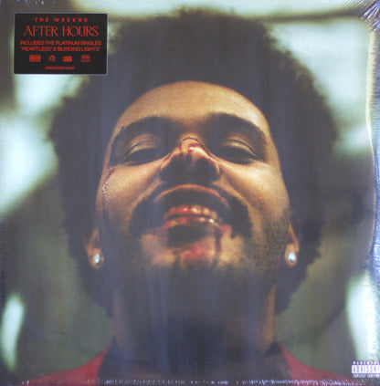 The Weeknd 'After Hours' vinyl record cover, sealed in shrink wrap, featuring a close-up portrait of the artist with a black hairpiece and a red shirt. A black sticker in the top-left corner lists included tracks, and a Parental Advisory label is visible in the bottom-right corner.